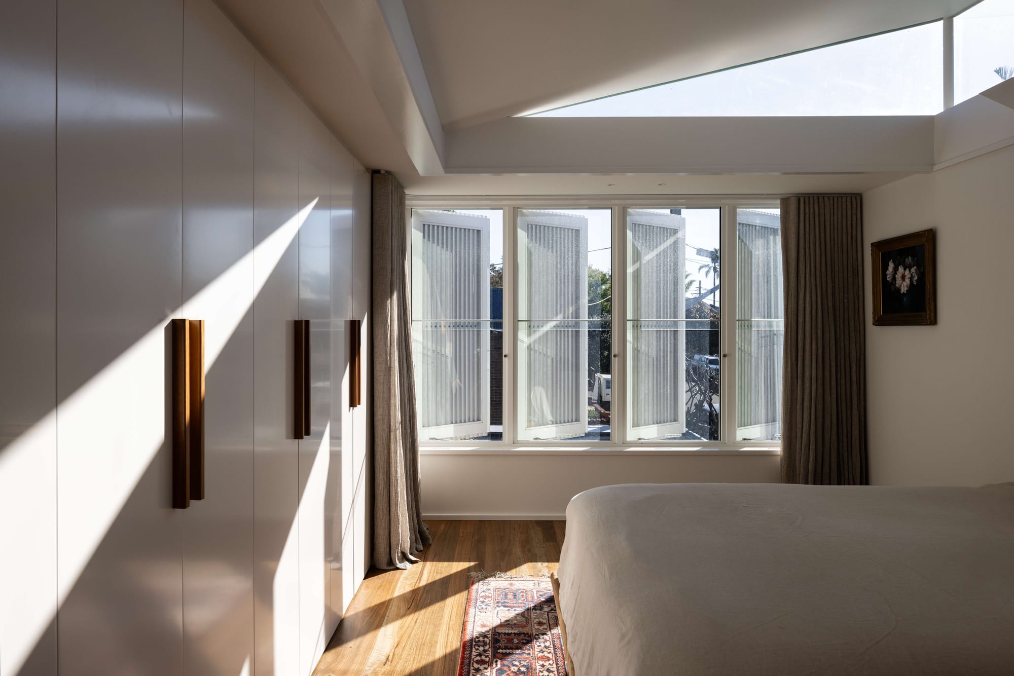 Bedroom with angled roof skylight and louvred glazing for privacy, Manly by Matt Day Architect