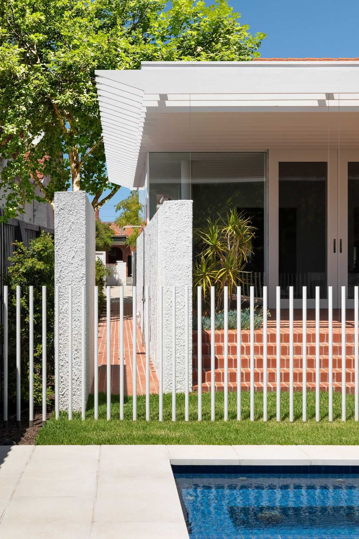 Elwood House by AM Architecture showing backyard pool with powdercoated white pool fence and a glimpse of the addition