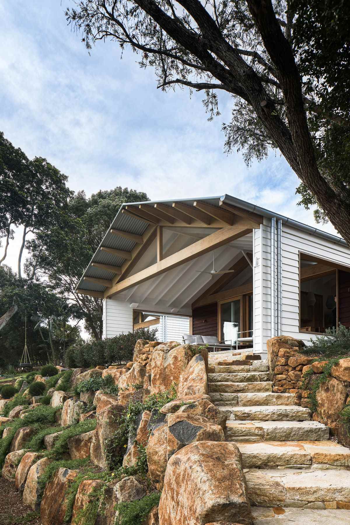 The Caretaker's by Aphora Architecture showing the natural stone path up to the house