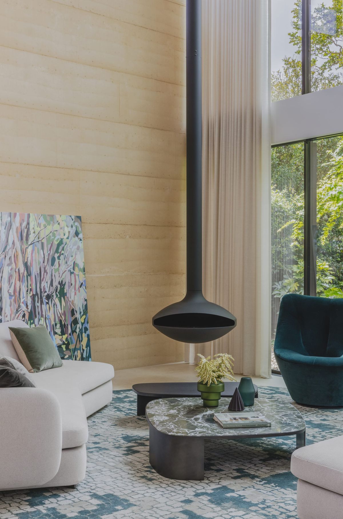 Interior of living space showing the hanging fireplace and well styled lounge room furniture