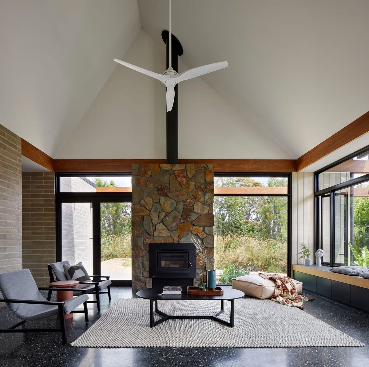 An interior shot showing the living room and stone fireplace with a vaulted ceiling.