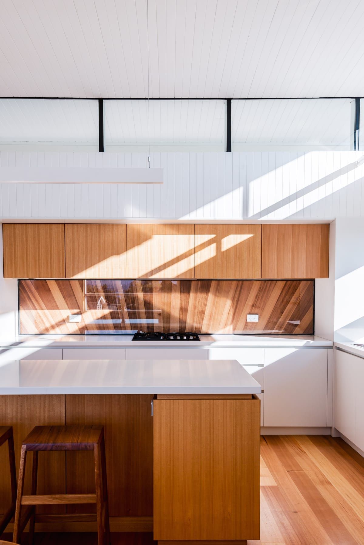 Wattle Bird House by Flett Architecture. Photography by Matt Sansom. Kitchen with timber floors and island bench. 
