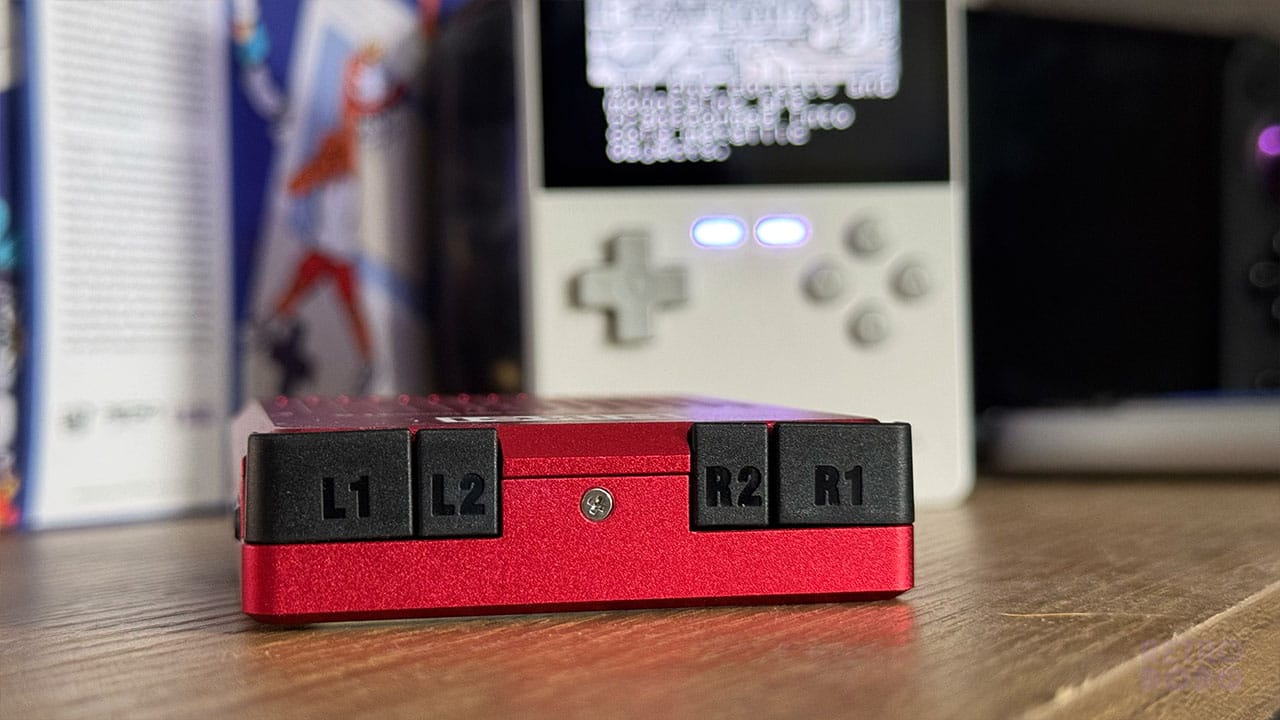 4 black plastic shoulder buttons on the top of a red metal handheld