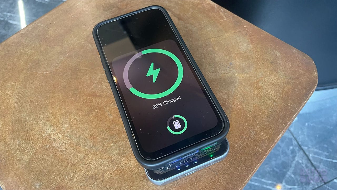 Seb charging his phone on the wireless charger part of the handheld