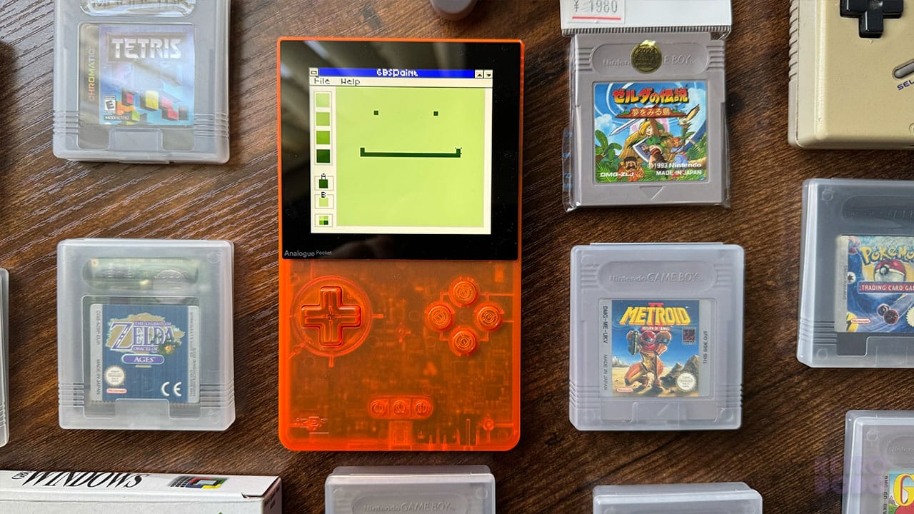 A smiley face drawn on Paint with Game Boy games surrounding the console