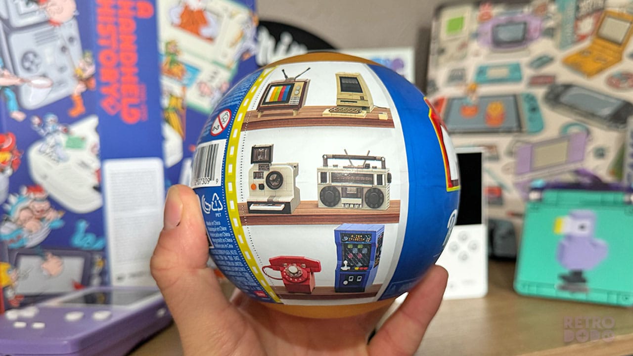 Seb holding a plastic orb showing 6 figurines in a retro set