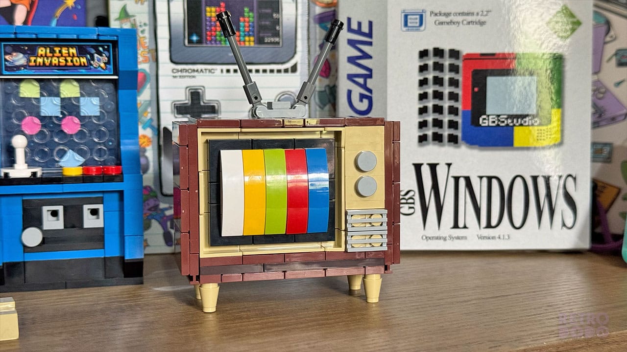 A toy retro TV next to some books and retro games