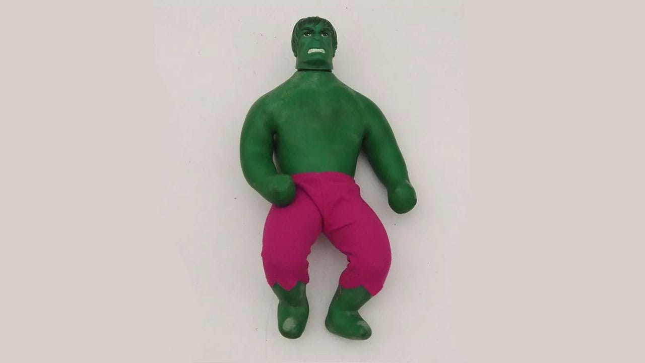 A green Hulk toy in pink trousers