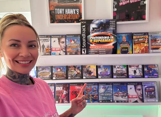 Maggie pointing at her Tony Hawk collection