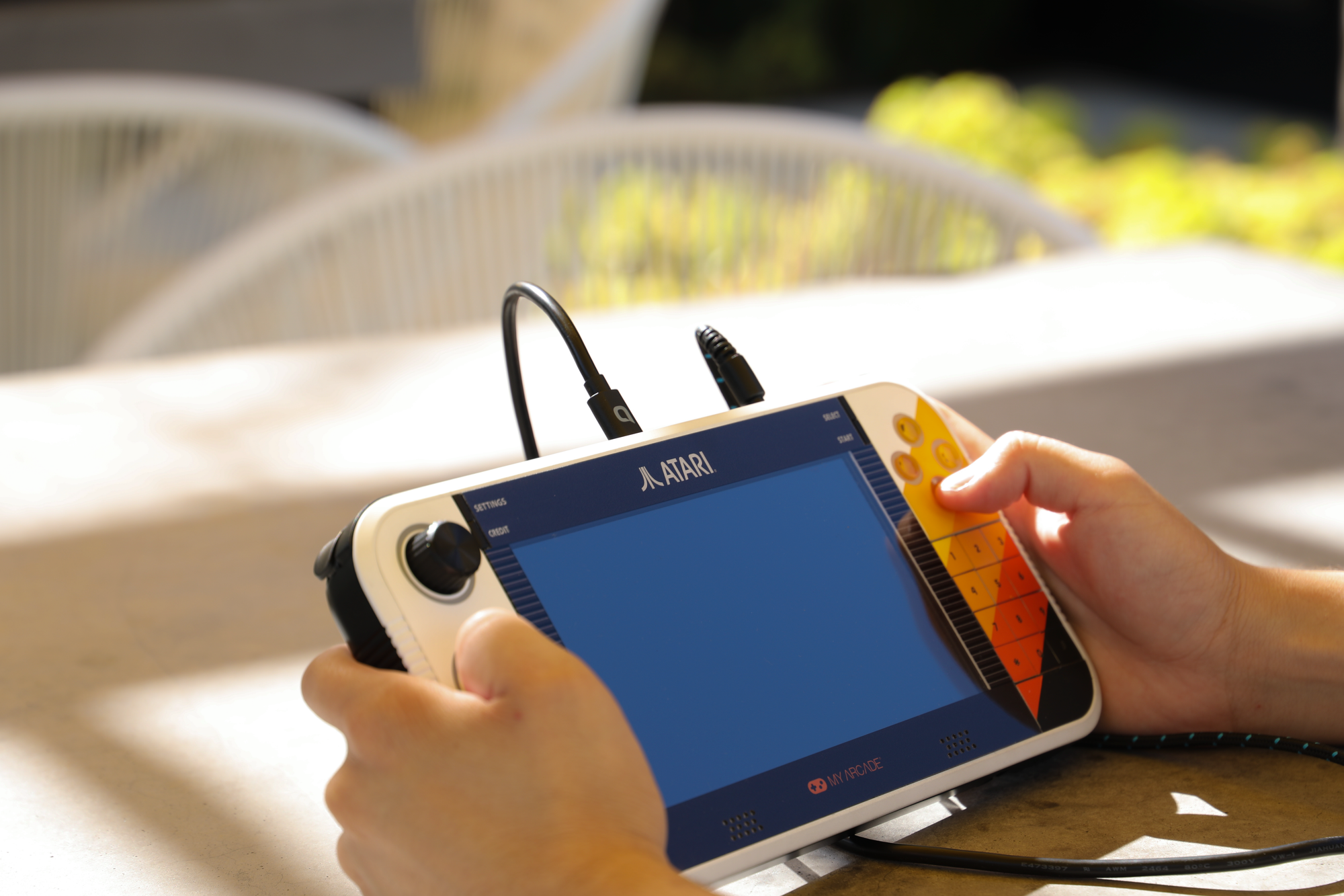 Someone holding a handheld console from Atari