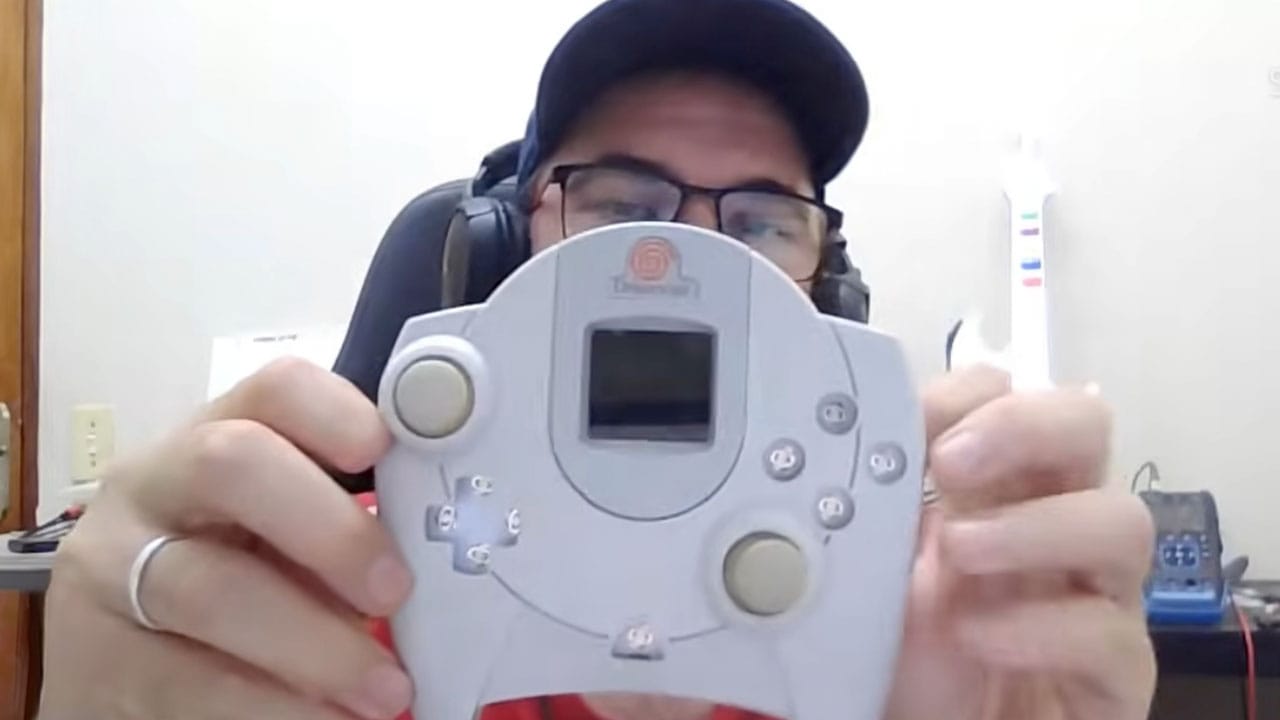 Angelo holding a dreamcast controller with two sticks