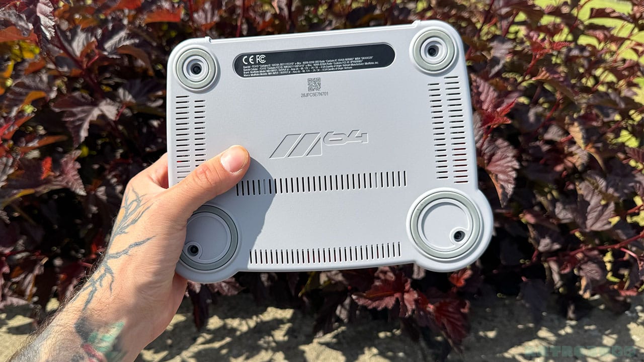 The bottom of the M64 console, showing grew rubber feet and a grey baseplate
