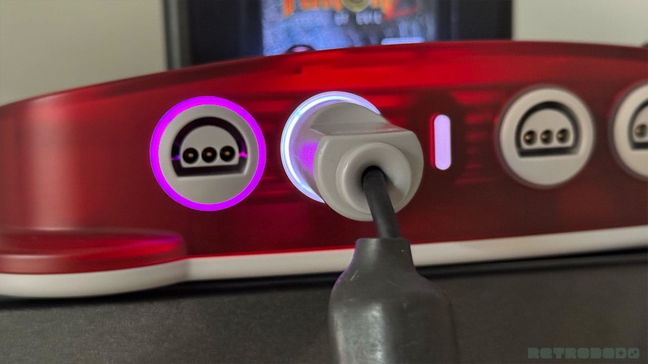 A purple light around an empty M64 socket showing a wireless connection is in place. There's a white LED around the next slot which has a controller plugged in