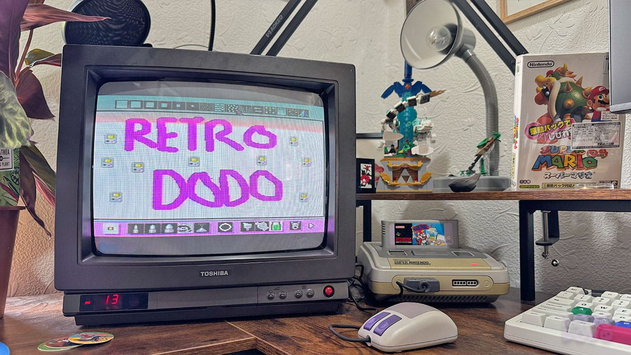 Seb's office with Mario Paint running. He has used the mouse to write Retro Dodo on the screen in purple letters