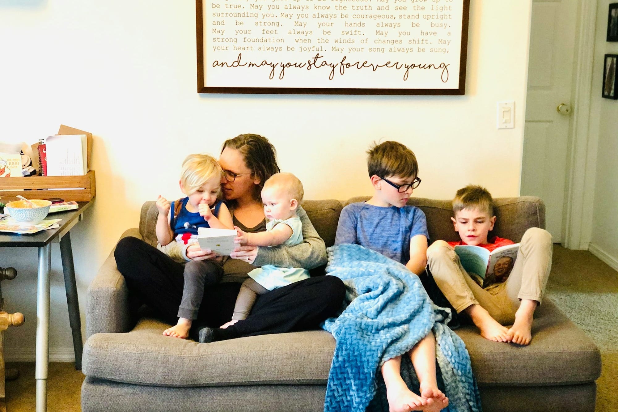 3 children sitting on gray couch