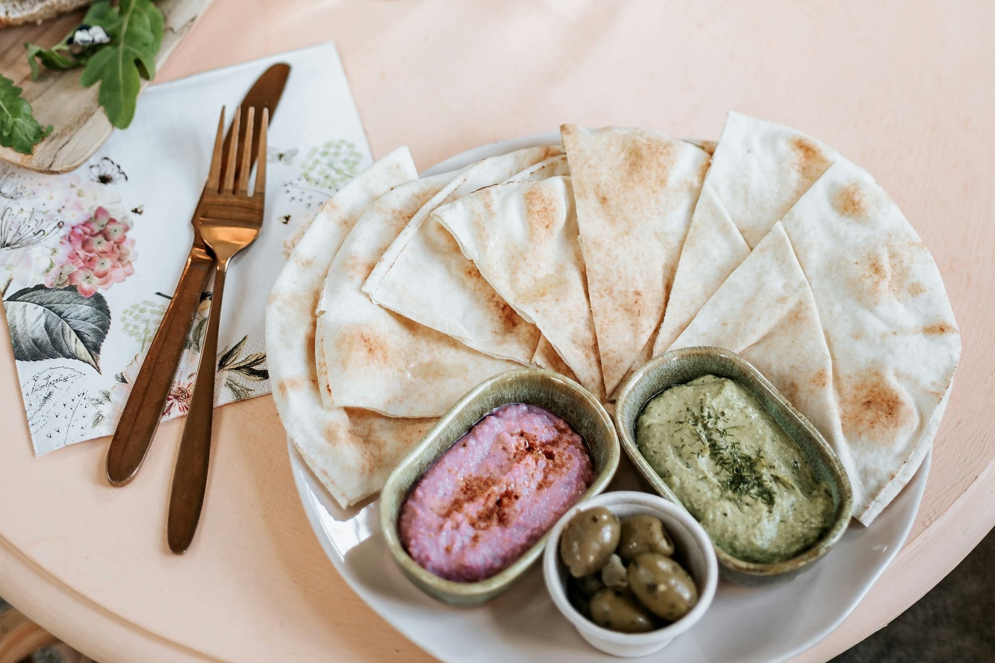 a table topped with a plate of food next to a vase of flowers