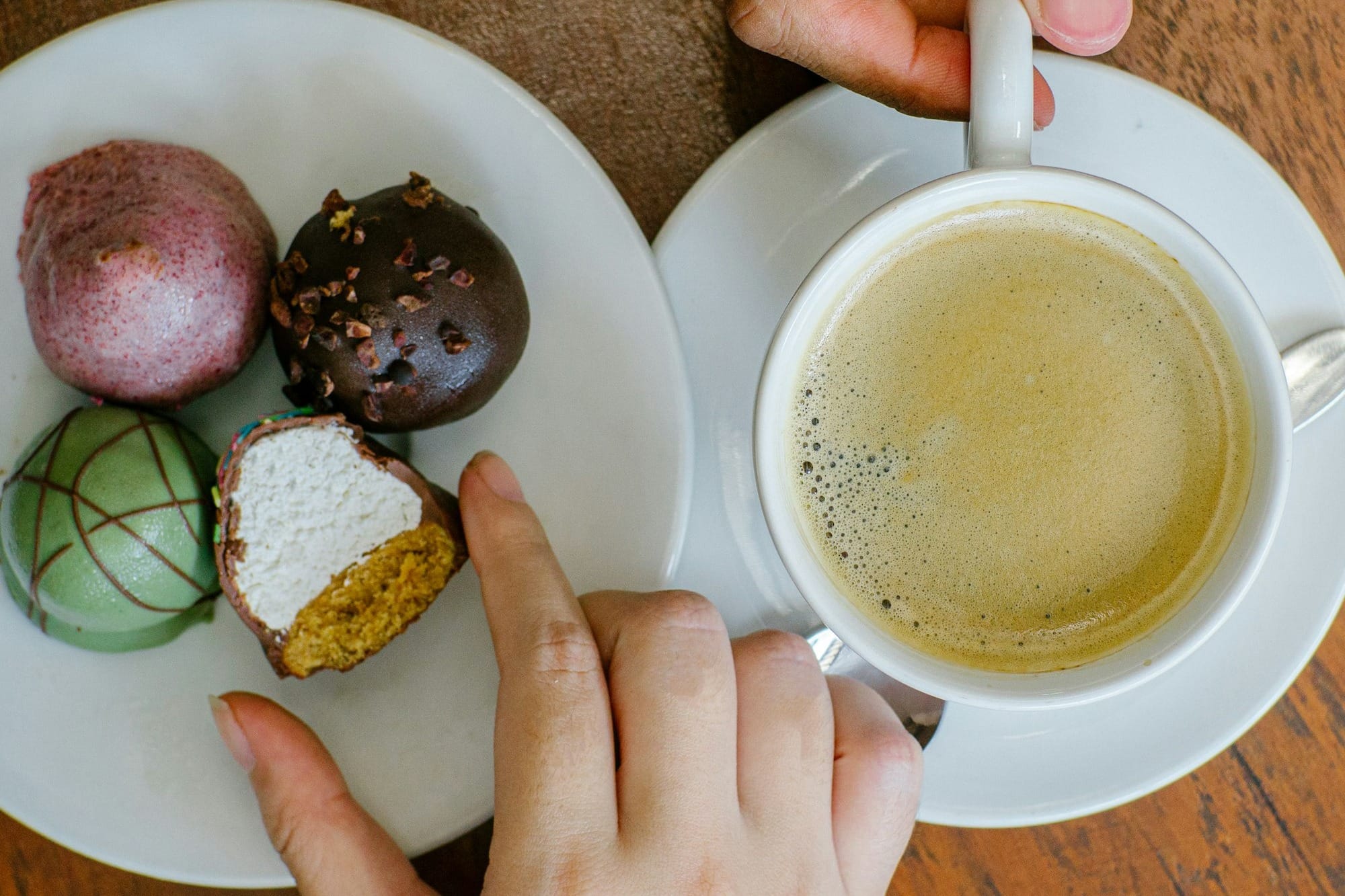 a person holding a cup of coffee and a plate of food