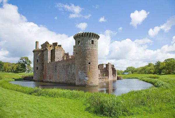 an image of a small medieval castle surrounded by a water filled moat