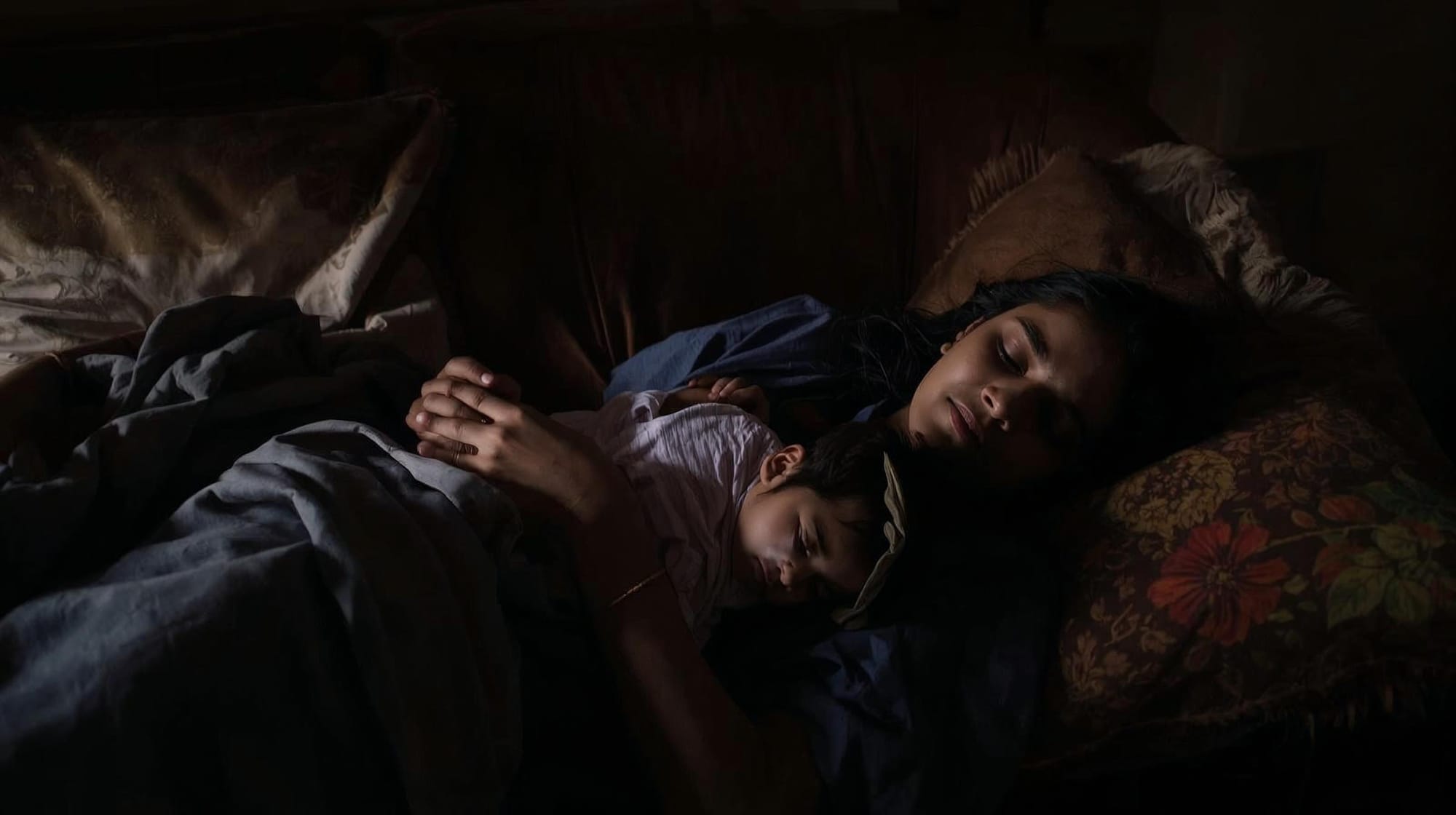 Postpartum mother resting with newborn — sleep deprivation and stress affect post-pregnancy weight