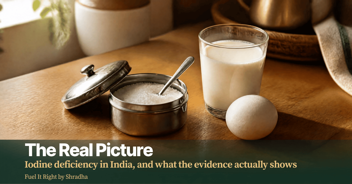 Photorealistic photo of a small dabba of iodised salt beside a glass of milk and a boiled egg on a kitchen counter, with headline "Iodine Deficiency in India: The Real Picture"