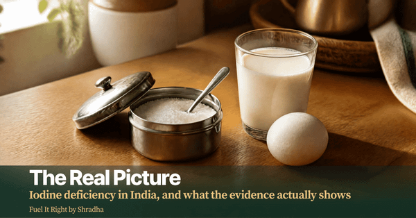 Photorealistic photo of a small dabba of iodised salt beside a glass of milk and a boiled egg on a kitchen counter, with headline "Iodine Deficiency in India: The Real Picture"