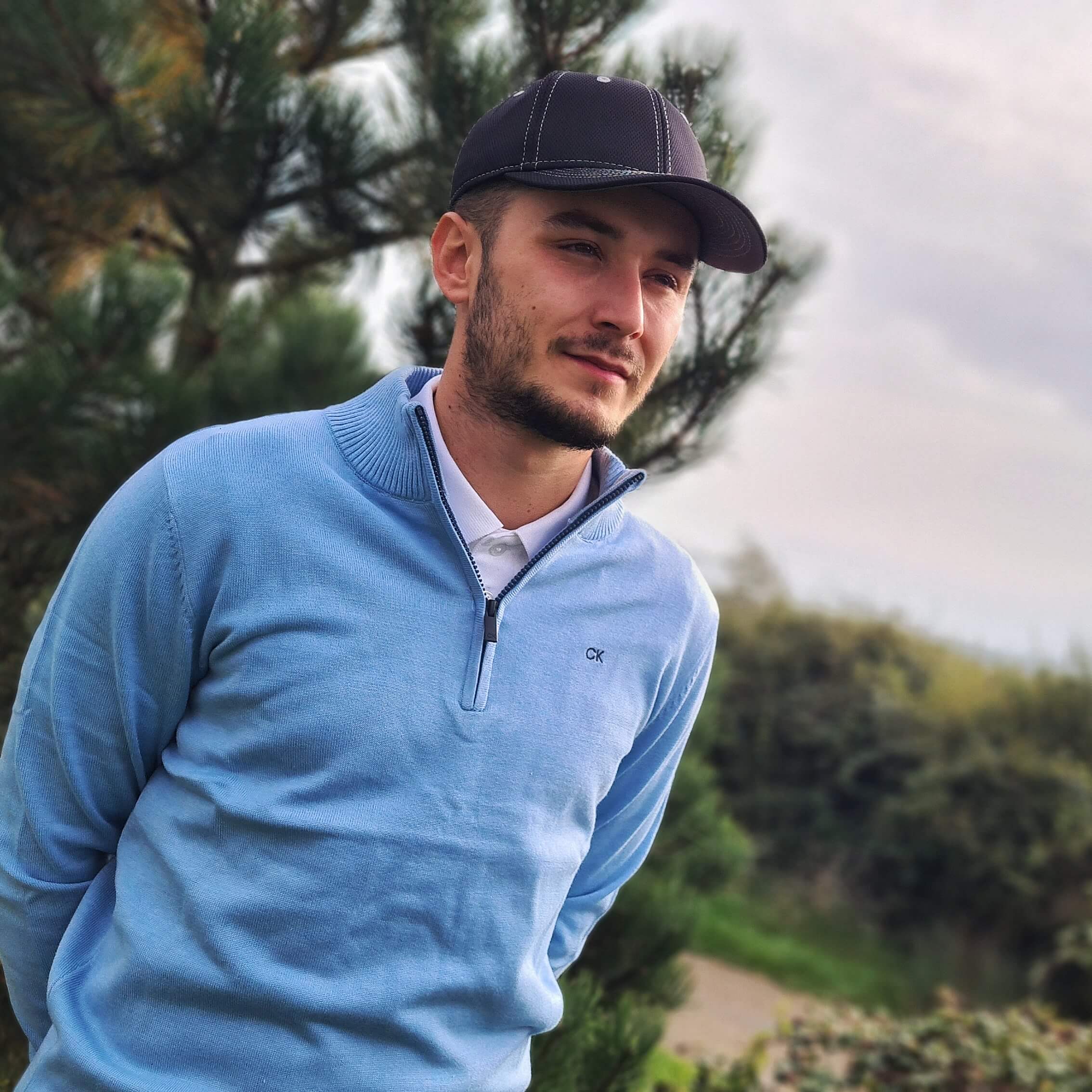 Male golfer wearing a light blue Calvin Klein Sweater