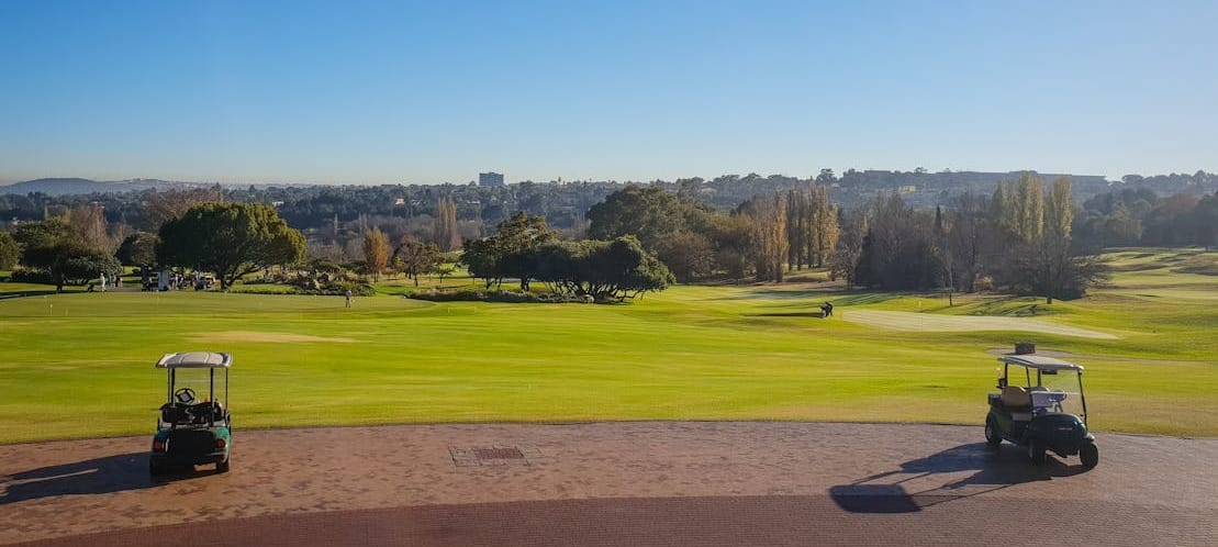 Two golf carts overlooking a sunny golf course