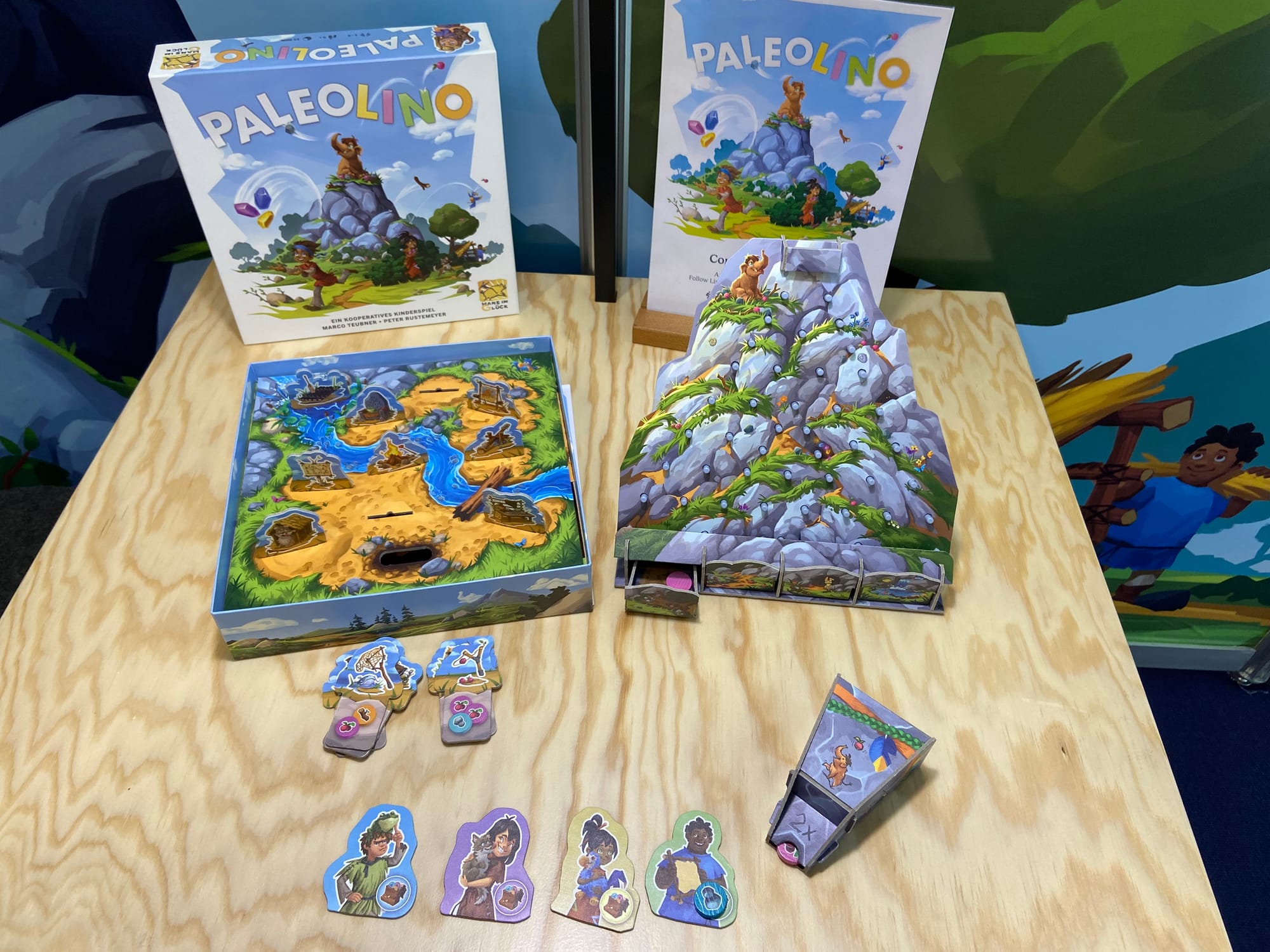 The same image as above, but pulled out so that the game box is visible, along with the stacks of invention tiles, the four player tiles, and the resource bag