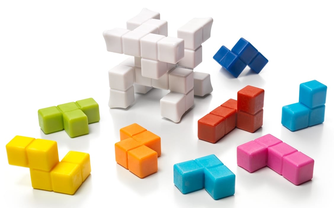 A 4x4x4 cube has many gaps within it, and eight colored plastic pieces are used to fill in the gaps