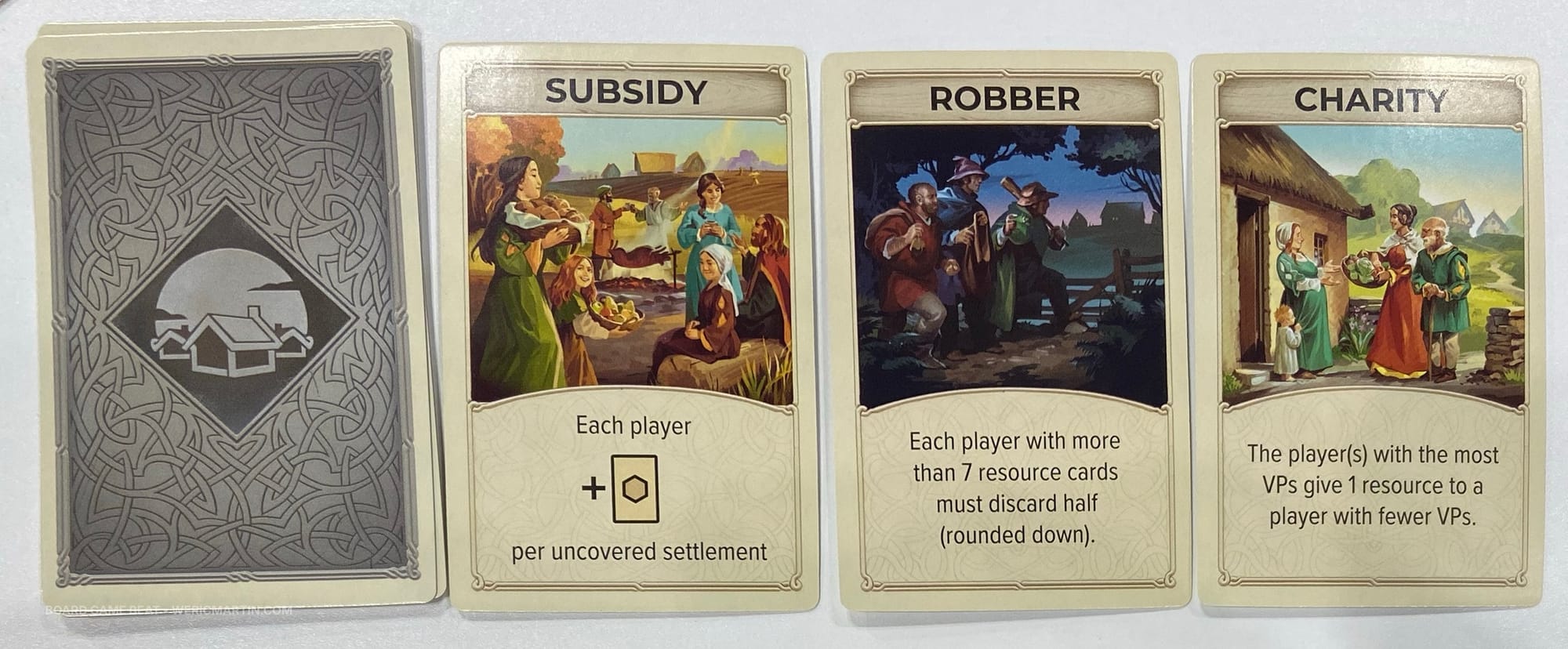 Sample "silver" cards in CATAN: On the Road, including a robber that takes resources and a subsidy that gives resources for uncovered settlments