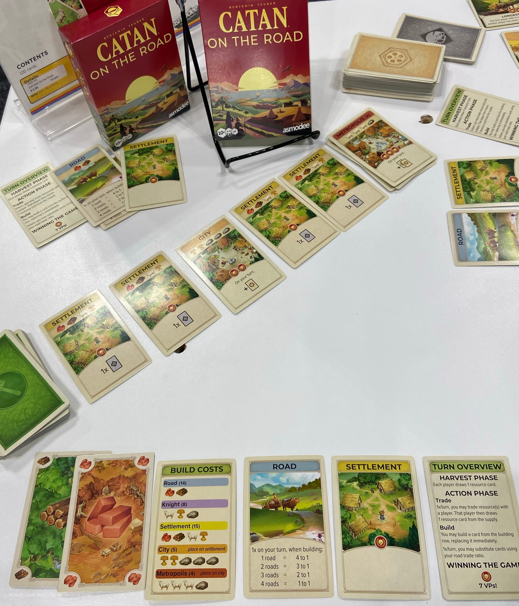 A layout of cards from CATAN: On the Road, including resource cards, roads, settlements, cities, and more