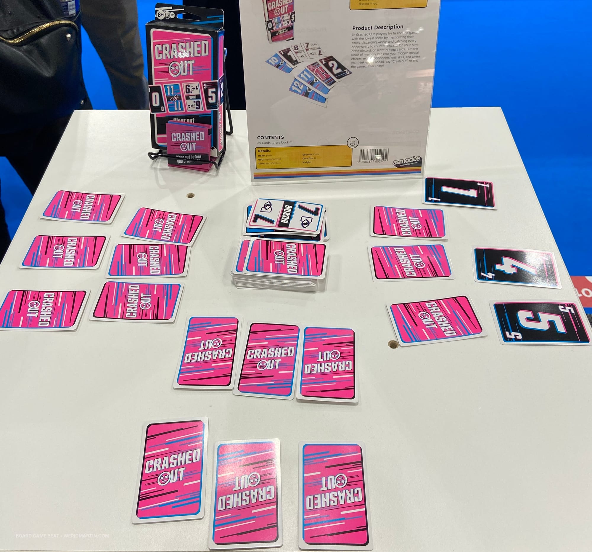 Lots of brightly pink cards labeled" Crashed Out" are on a table, with some flipped to reveal numbers or actions