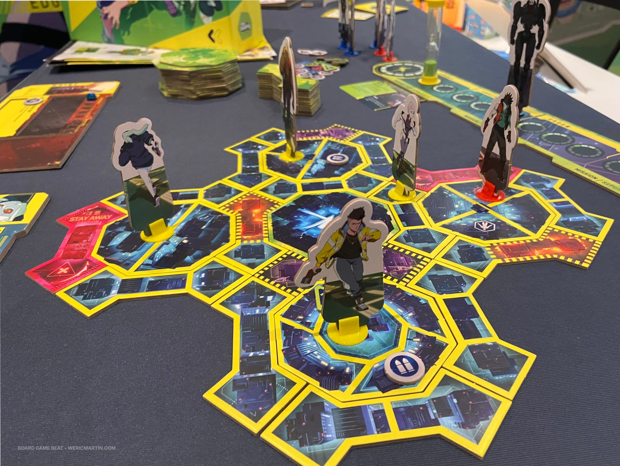 A grid of octagonal and arrow-shaped tiles form a complete grid that's occupied by cardboard standees in various regions