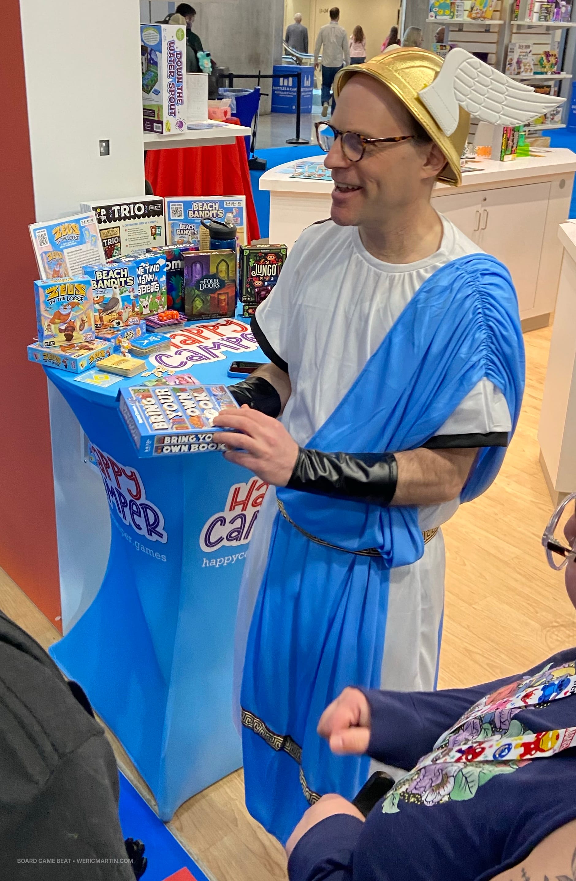 Jason Schneider of Happy Camper wears a Greek toga and a winged helmet akin to Hermes