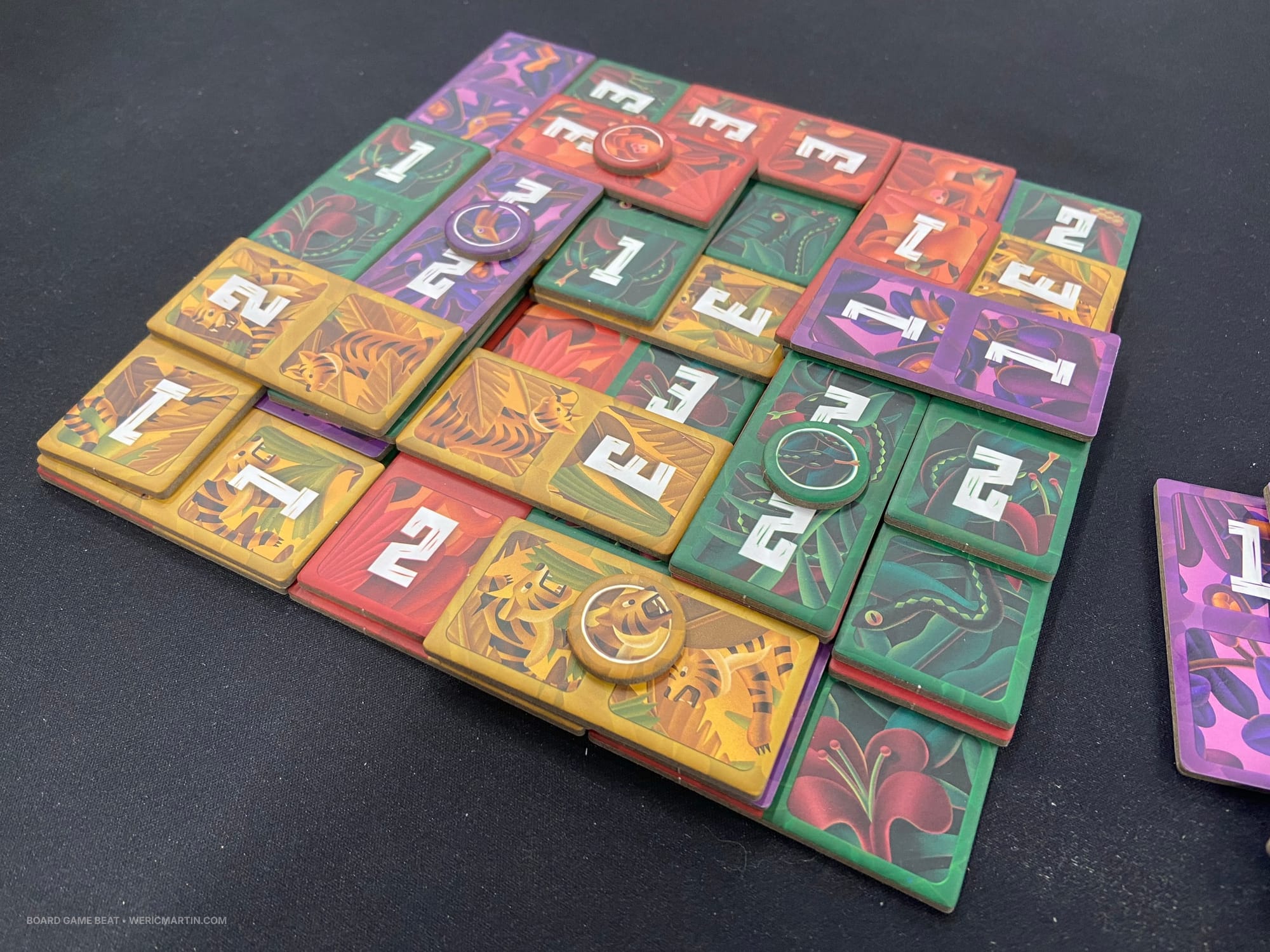 A demonstration of Kumata, with numbered tiles in four colors stacked multiple levels high