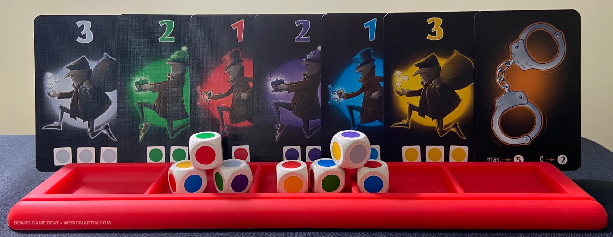 Cards numbered 1-3 in the six colors, along with a handcuff card and seven dice
