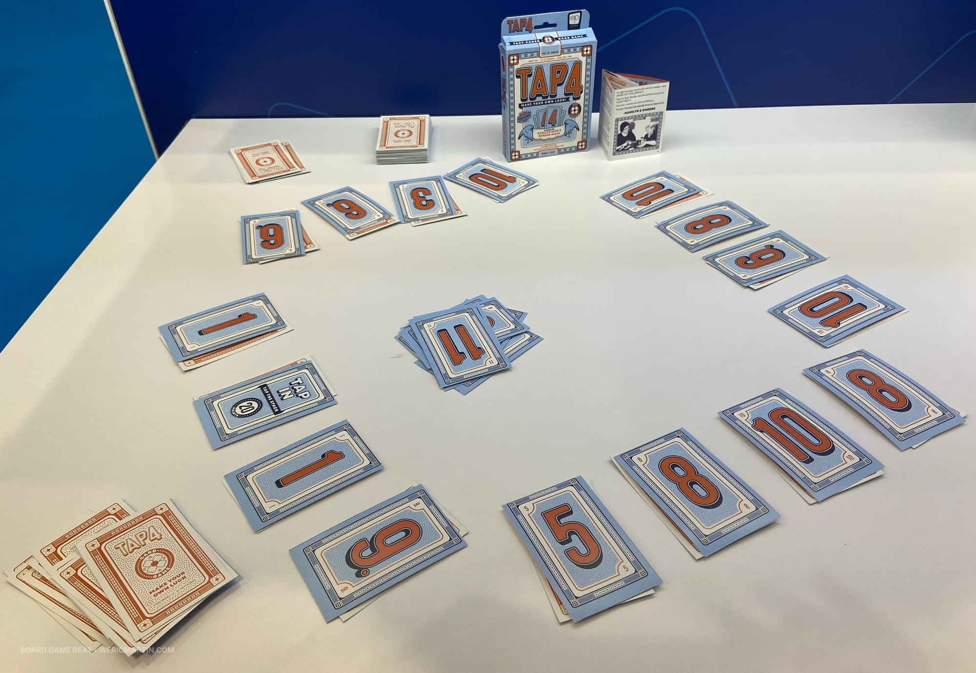 Numbered cards are in four piles in front of each player, with some cards being played in the center of the table