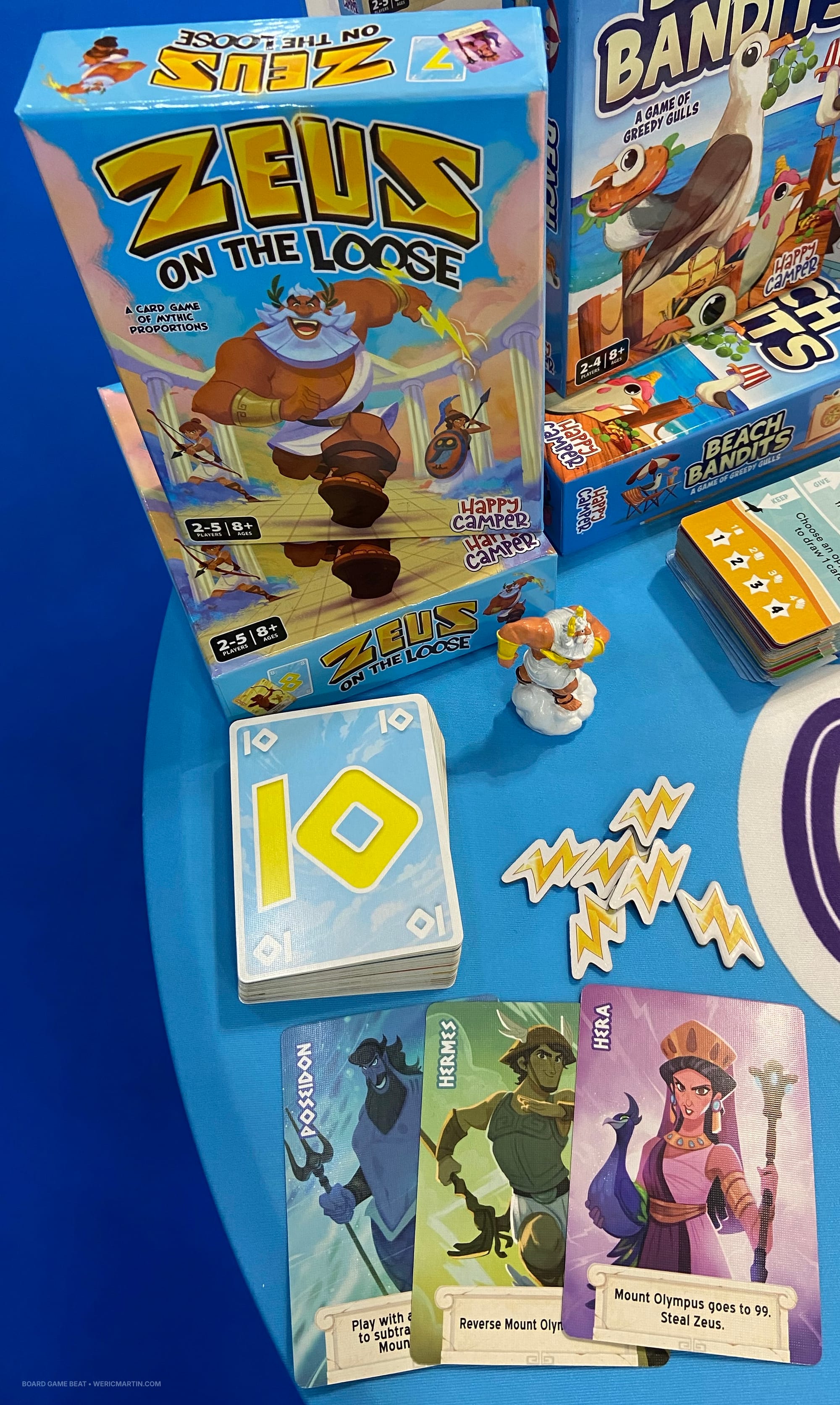 Sample cards from Zeus on the Loose, a Zeus figure, and lightning bolt tokens