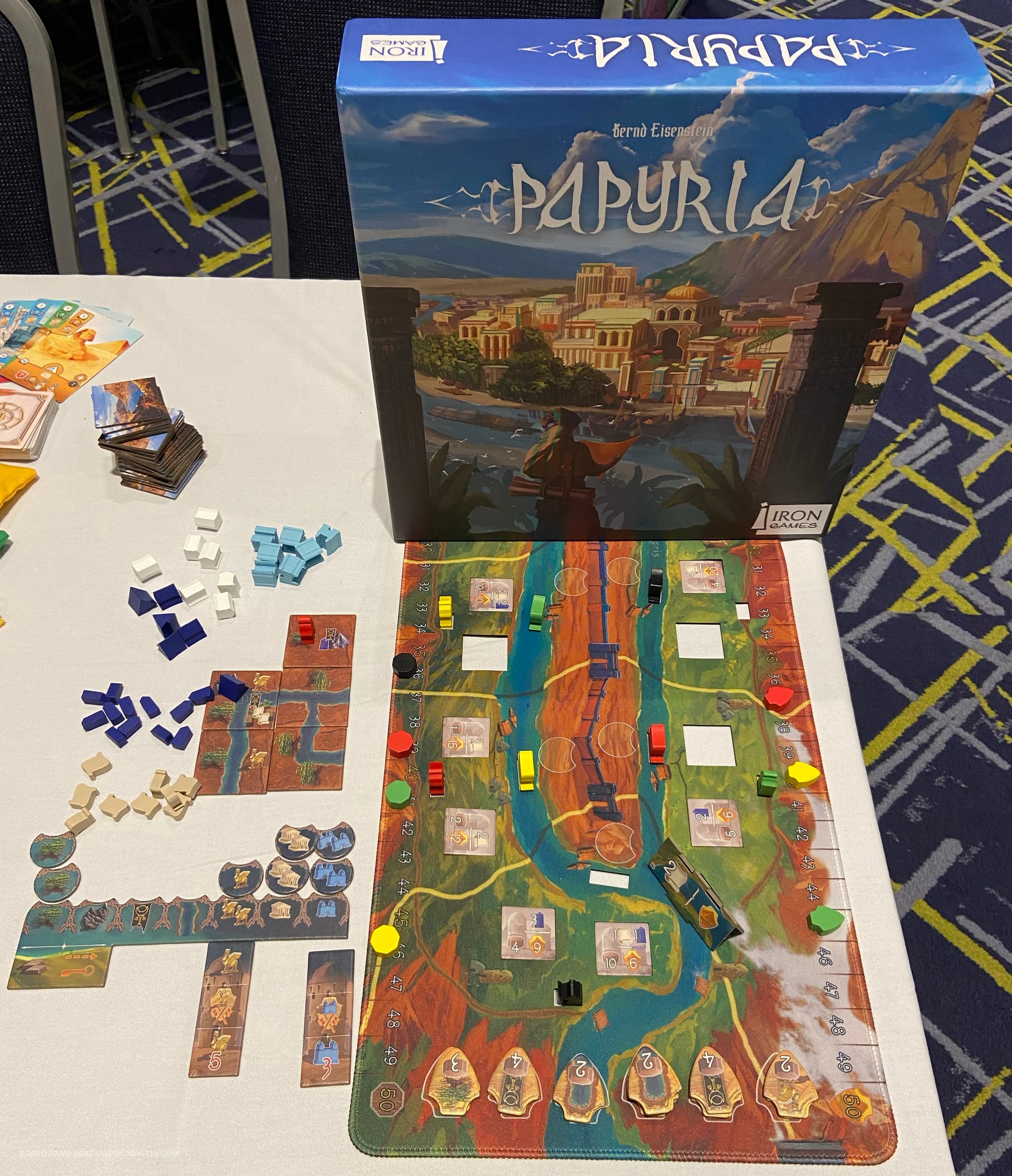 The game box for Papyria next to the game board and components 