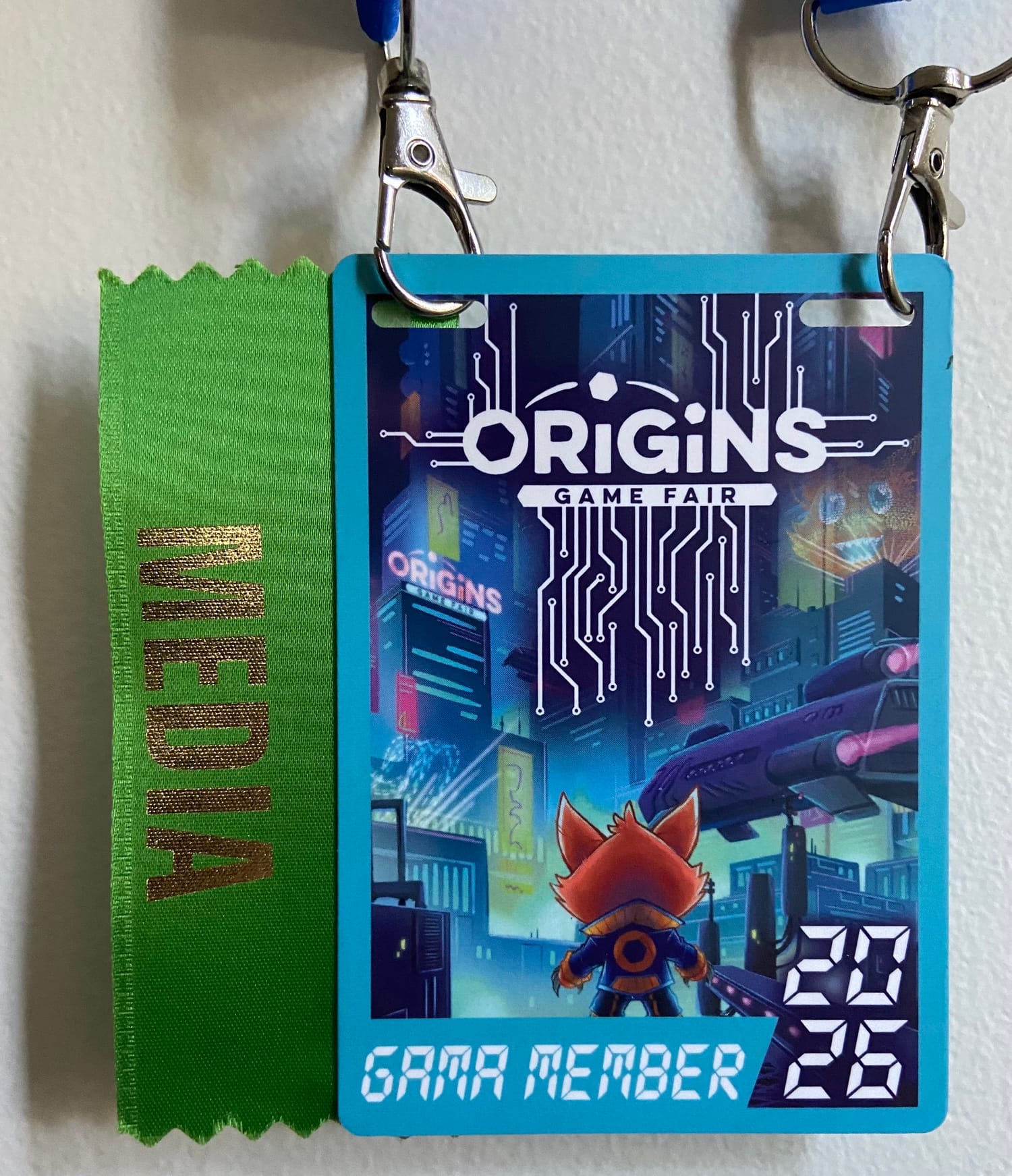 An image of a Origins Game Fair 2026 entry badge, with a MEDIA ribbon attached to the left-hand edge