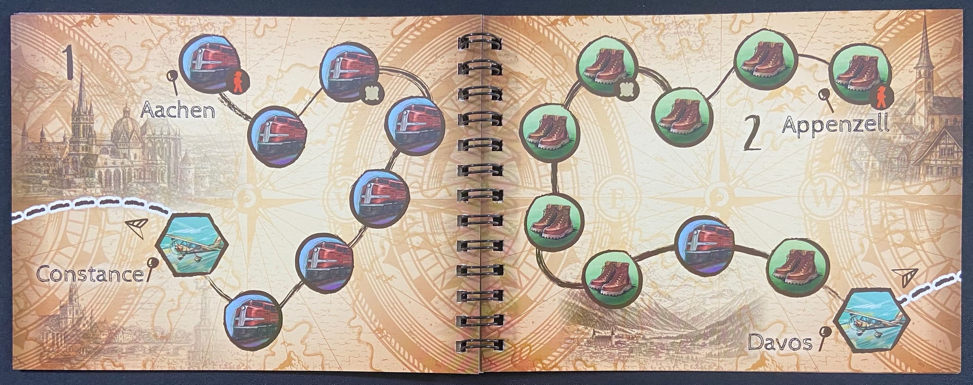 A spiral-bound notebook is open to show two pages, numbered 1 and 2, with a path of circles on each page and method of transportation depicted in each circle.