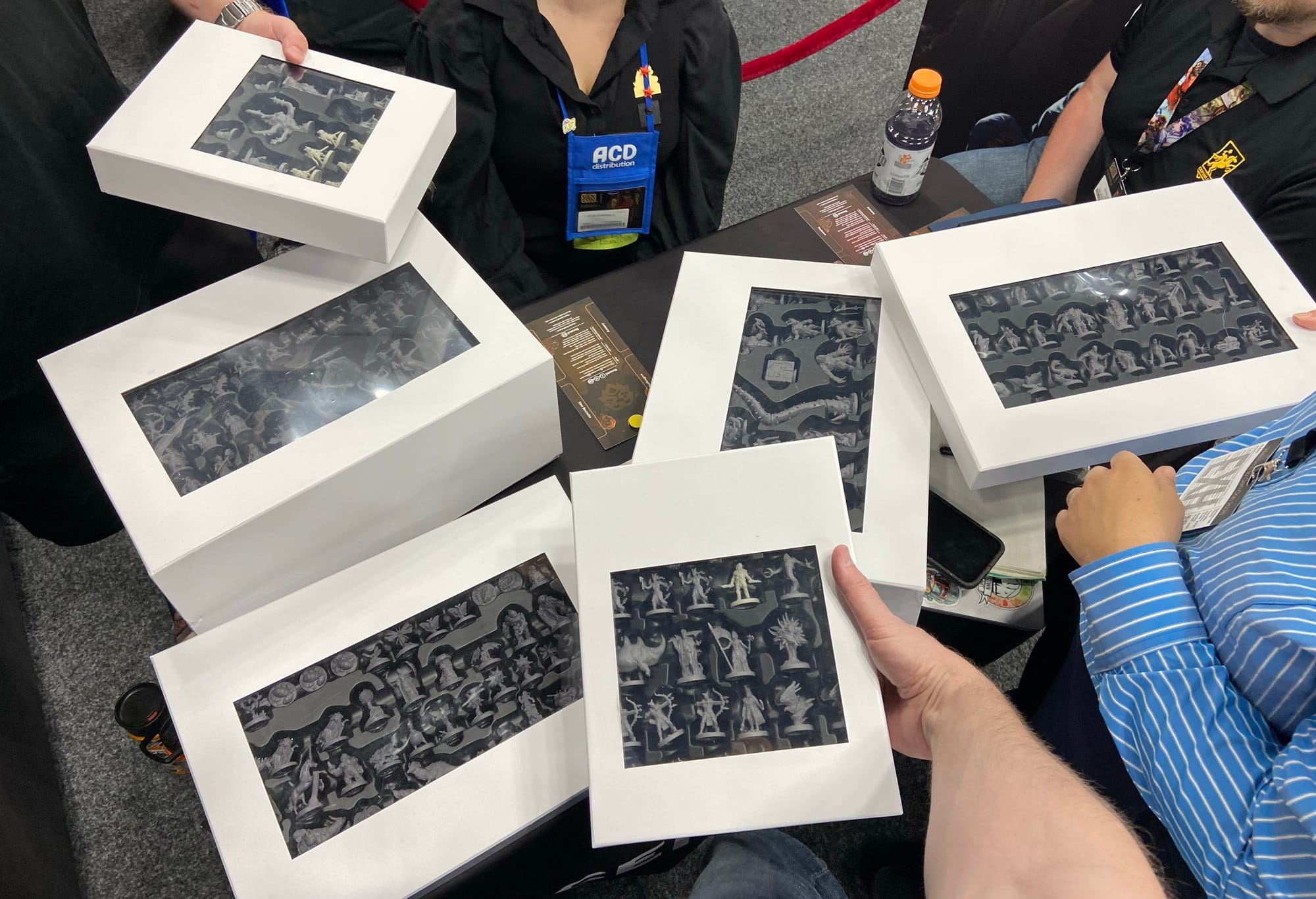 Six boxes of miniatures are visible, with a plastic window on each box allowing you to see some of the figures.