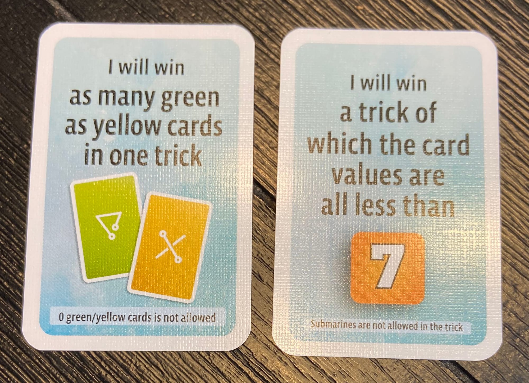 The two tasks: "I will win as many green as yellow cards in one trick" and "I will win a trick of which the card values are all less than 7"