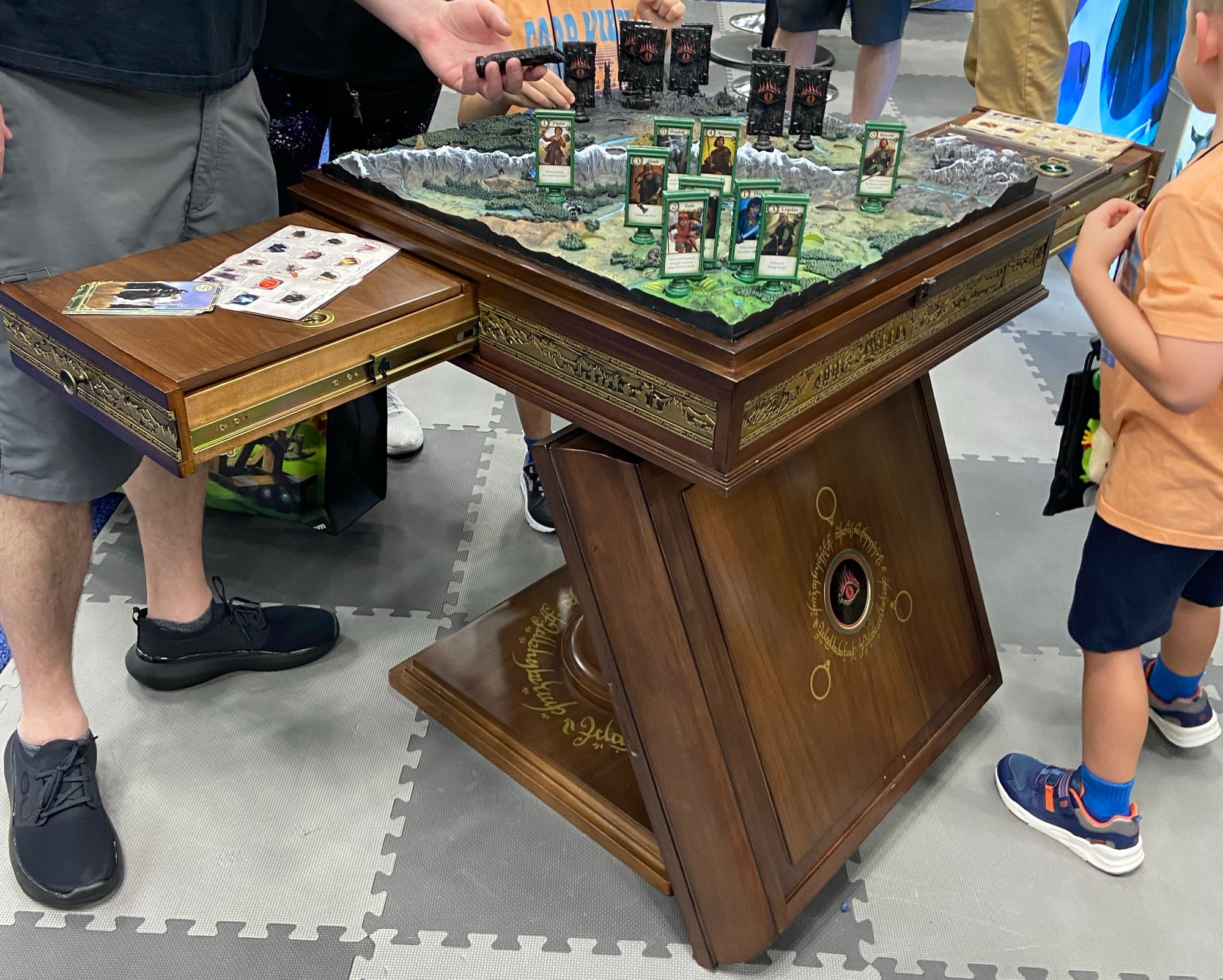 An incredibly fancy wooden table holds the "ultimate" edition of The Lord of the Rings: Confrontation