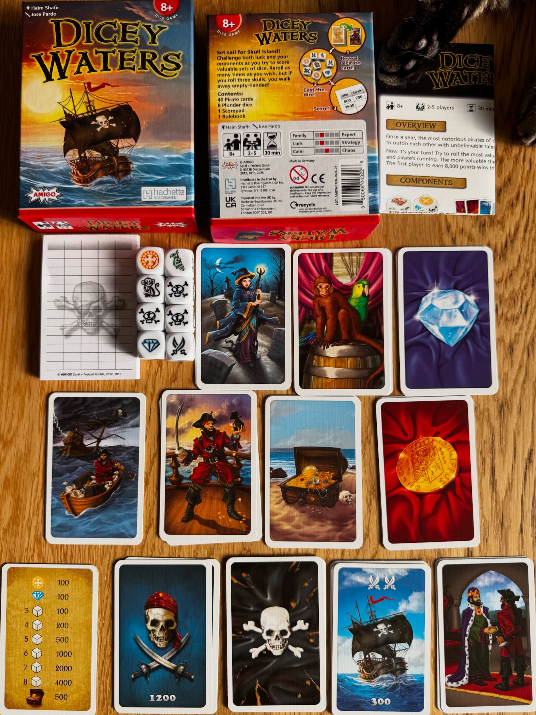 Front and back cover of Dicey Waters, along with the eight dice and sample fortune cards in the deck.