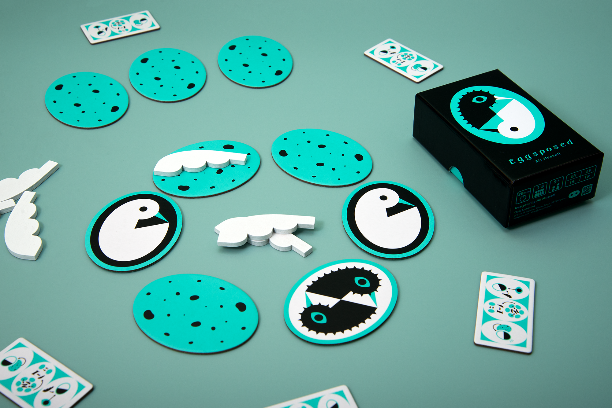 Six eggs are in a circle, with three being face up (showing a bright bird, a bright bird, and a pair of night birds) and one bearing a feather.