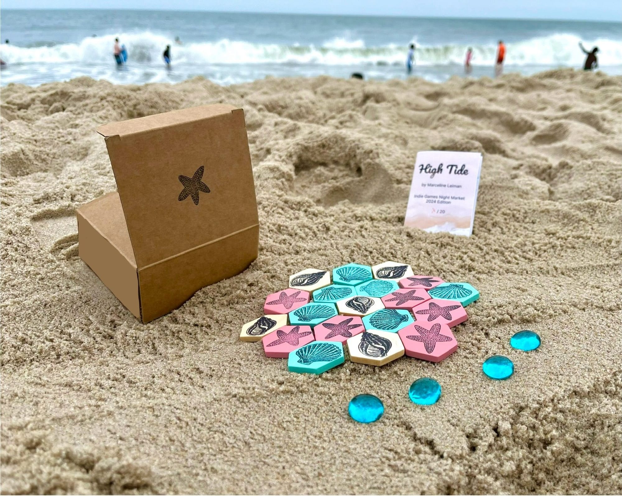 Nineteen tiles in three colors are placed in a hexagonal grid on the beach.