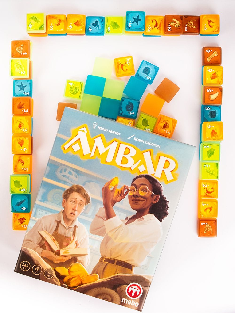 The Âmbar box shows two people looking at a piece of amber; also included in the image are three rows of ten tiles, along with a pool of face-up and face-down tiles.