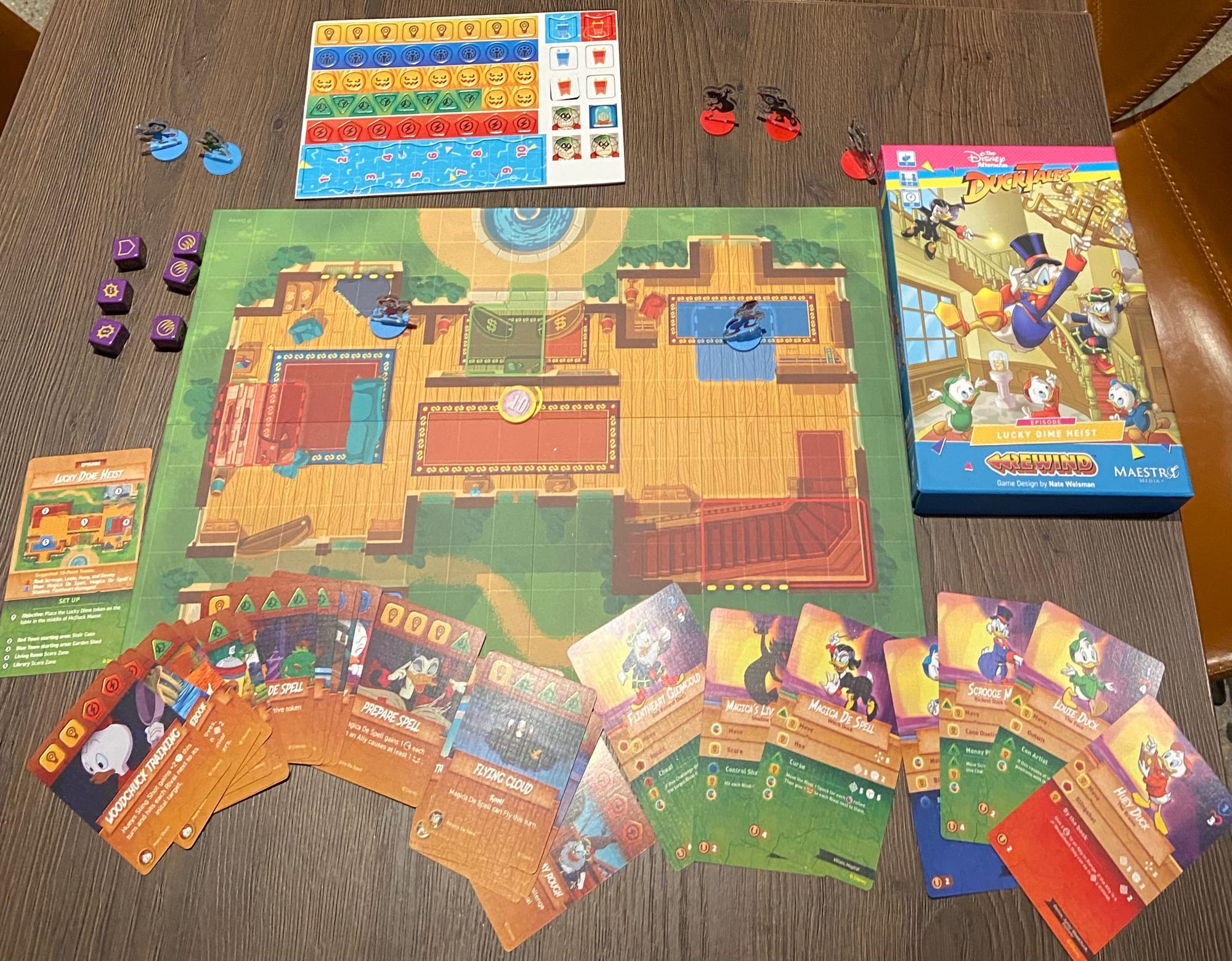 The components of DuckTales: Lucky Dime Heist are on display: game board, cards, tokens, and box.