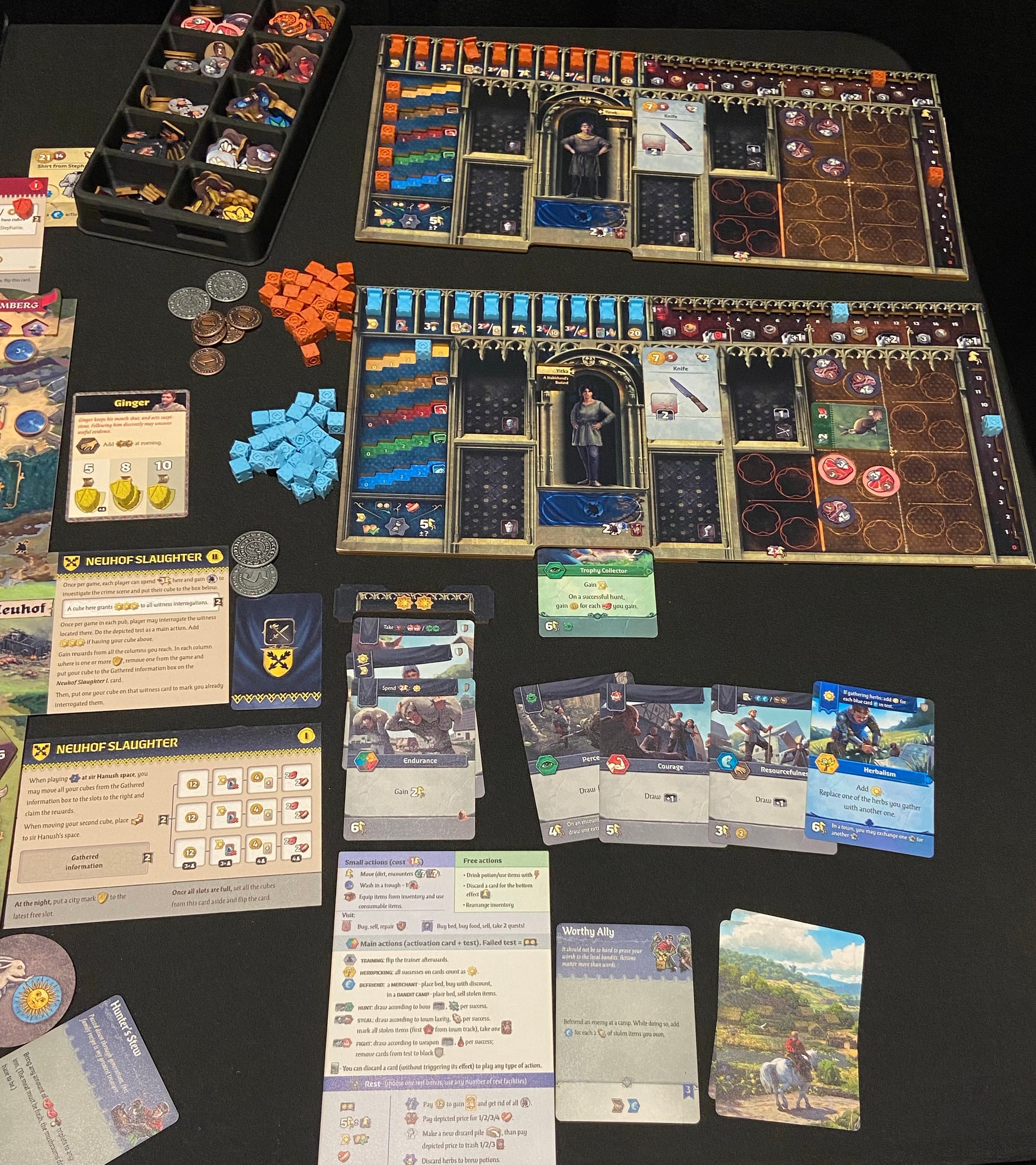 Two player game boards are depicted, which show a character stats, bonuses you can achieve, room for equipment and tools, and more.